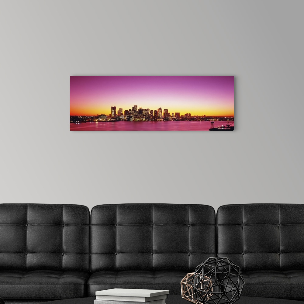 A modern room featuring Big, wide angle photograph of a distant Boston skyline, with lit skyscrapers at sunset.