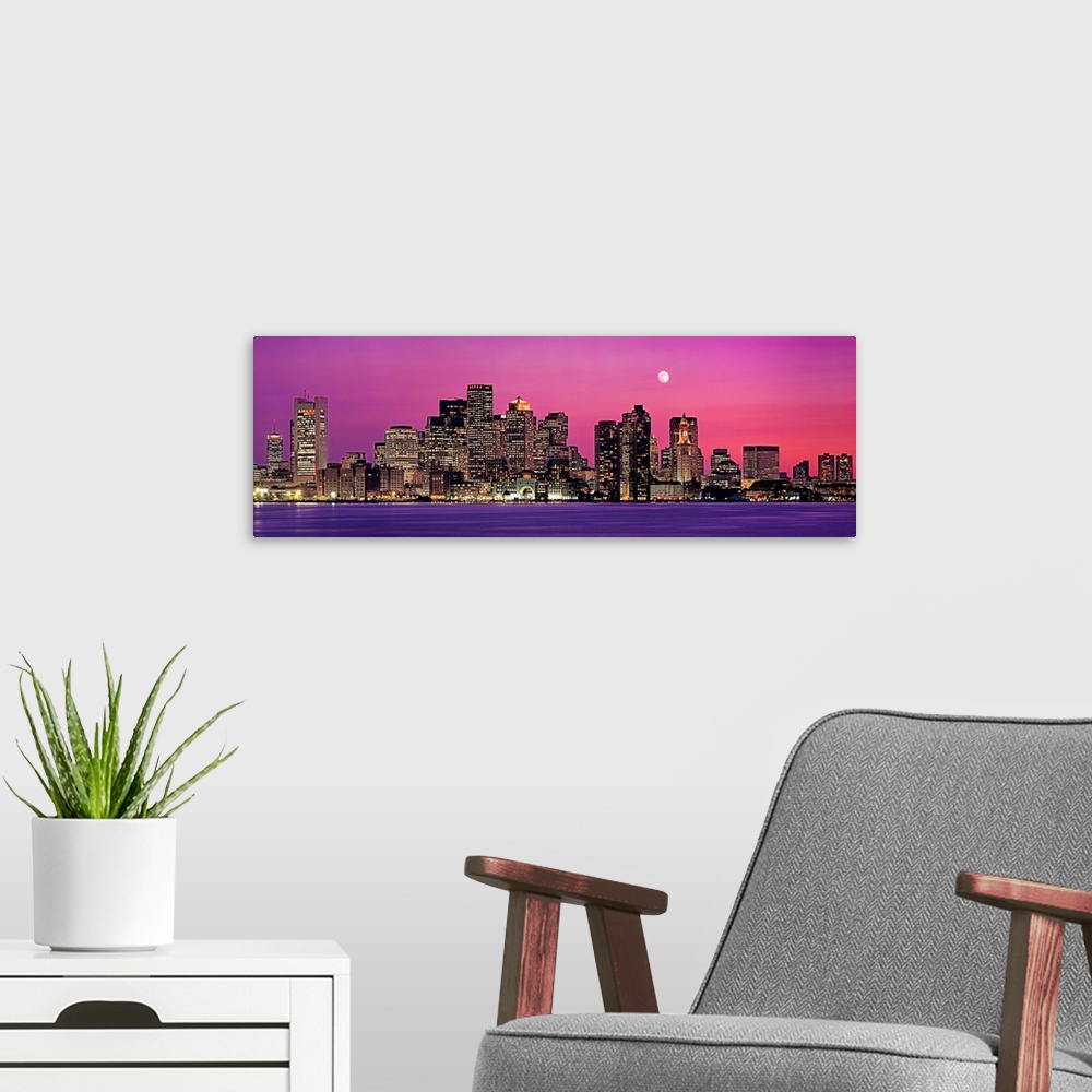 A modern room featuring Panoramic photograph of a skyline in Boston, Massachusetts at night by the shore.  The moon in th...
