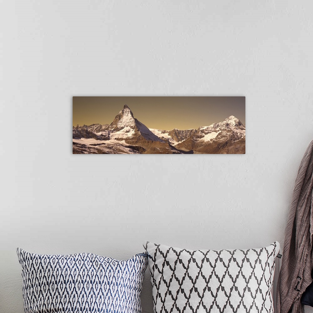 A bohemian room featuring Large, landscape photograph of Matterhorn mountain, lightly covered with snow, in Switzerland.