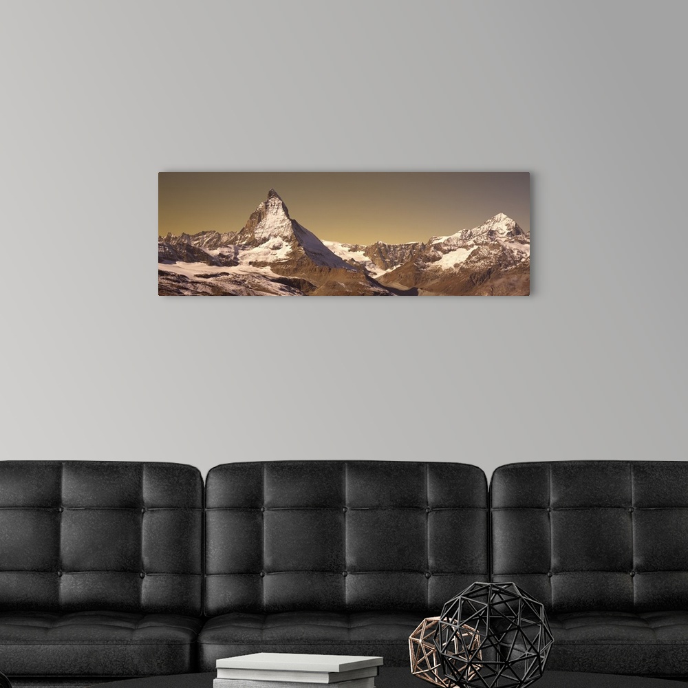 A modern room featuring Large, landscape photograph of Matterhorn mountain, lightly covered with snow, in Switzerland.