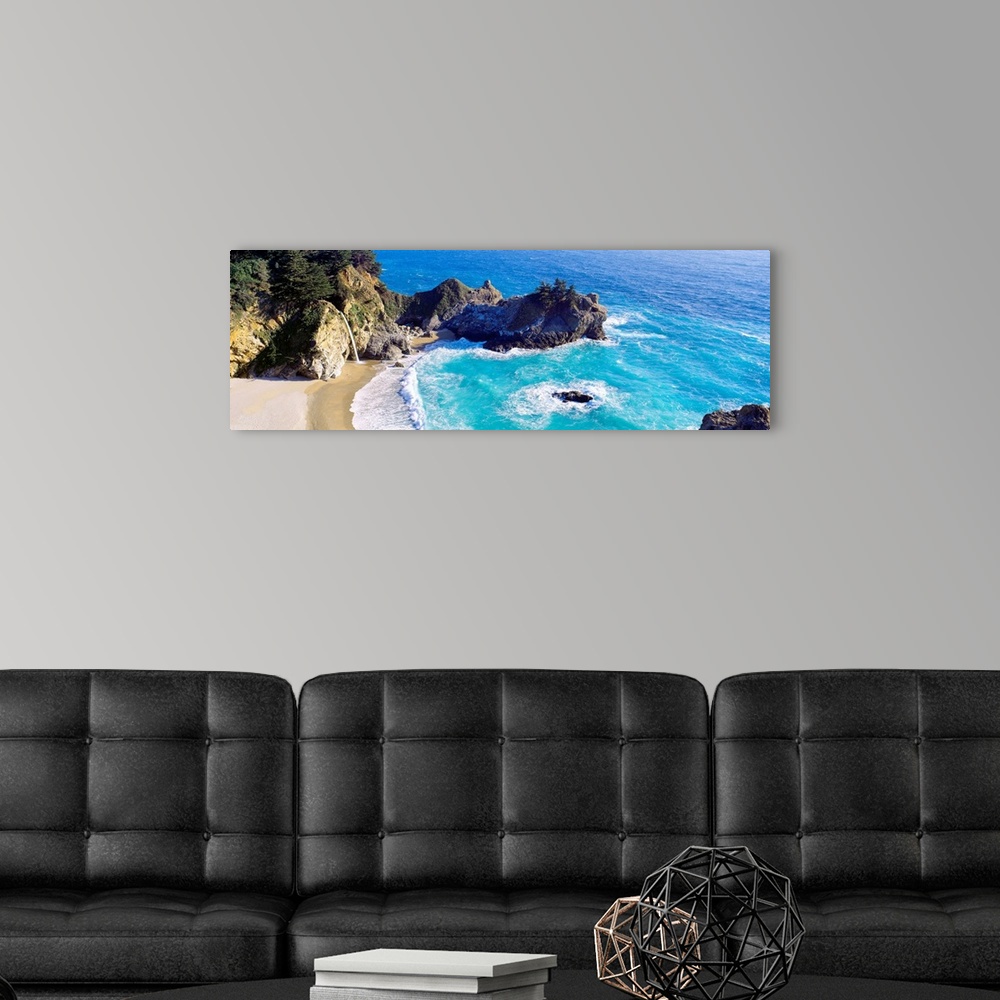A modern room featuring Panoramic photograph of waves from the Pacific ocean crashing into the jagged rocks within McWay ...