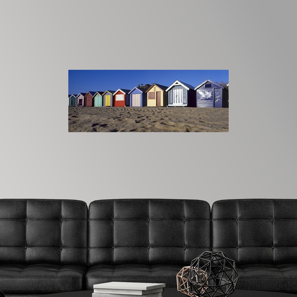 A modern room featuring A row of colorful huts are photographed lining the sandy beach.