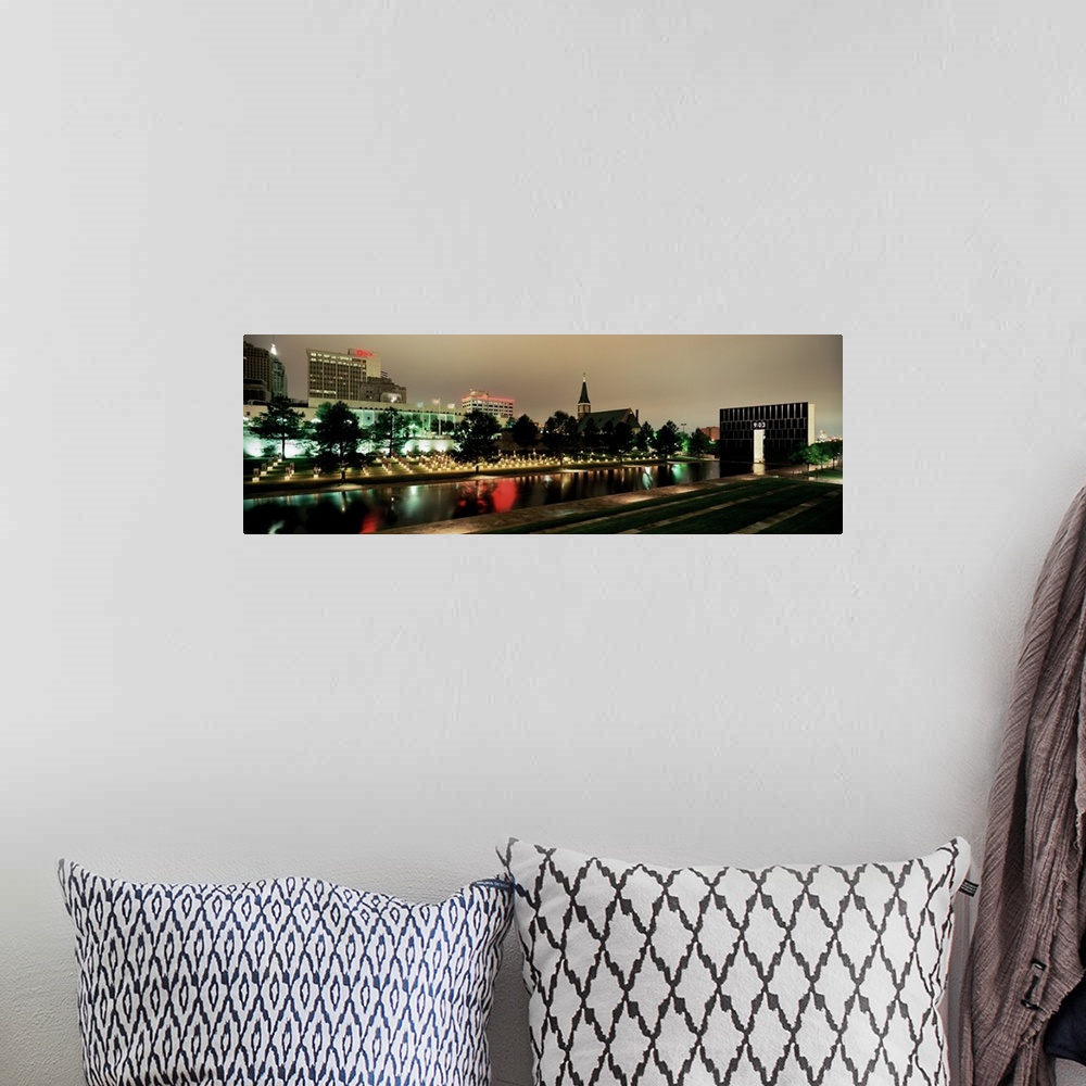 A bohemian room featuring Panoramic photograph of skyline and waterfront at nigh.  The building lights are reflected in the...