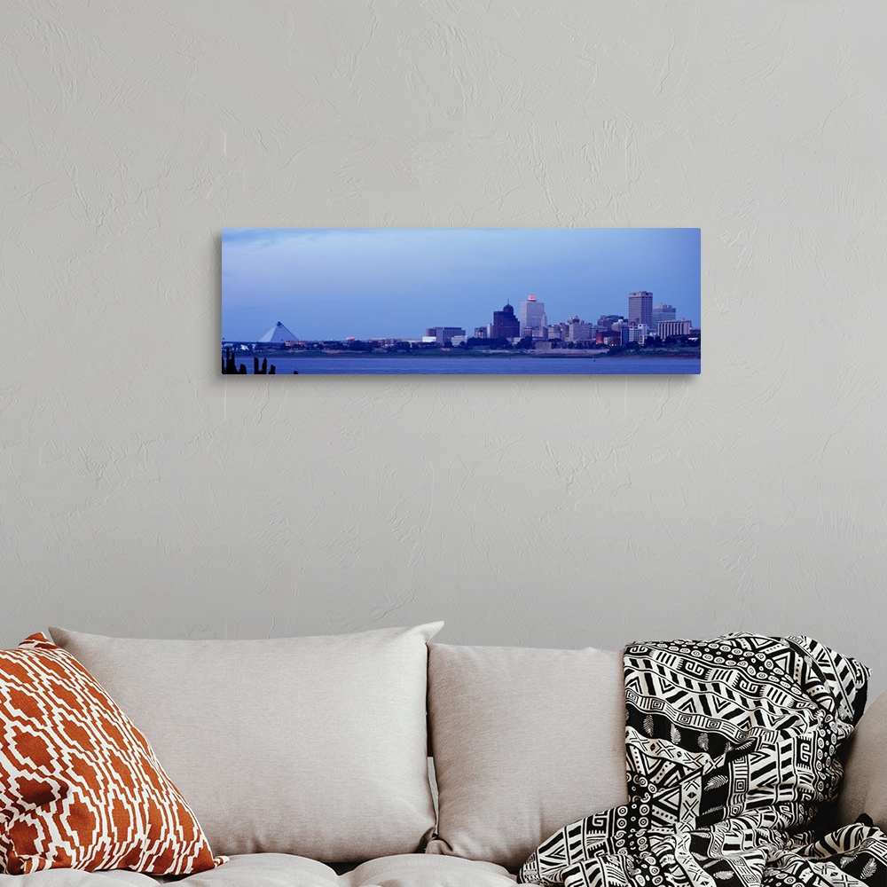 A bohemian room featuring The skyline in Memphis Tennessee is photographed from a distance across a body of water. There is...