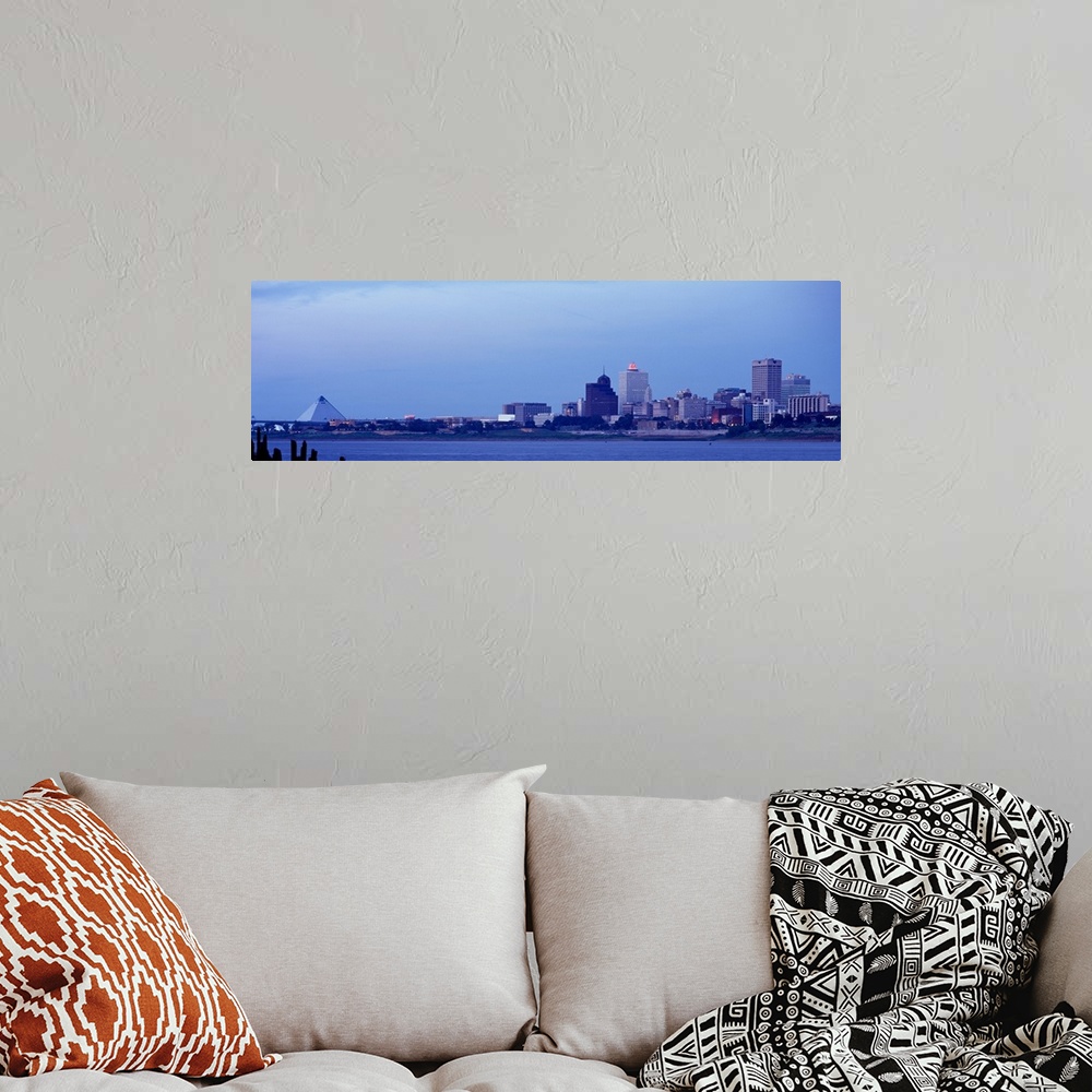 A bohemian room featuring The skyline in Memphis Tennessee is photographed from a distance across a body of water. There is...