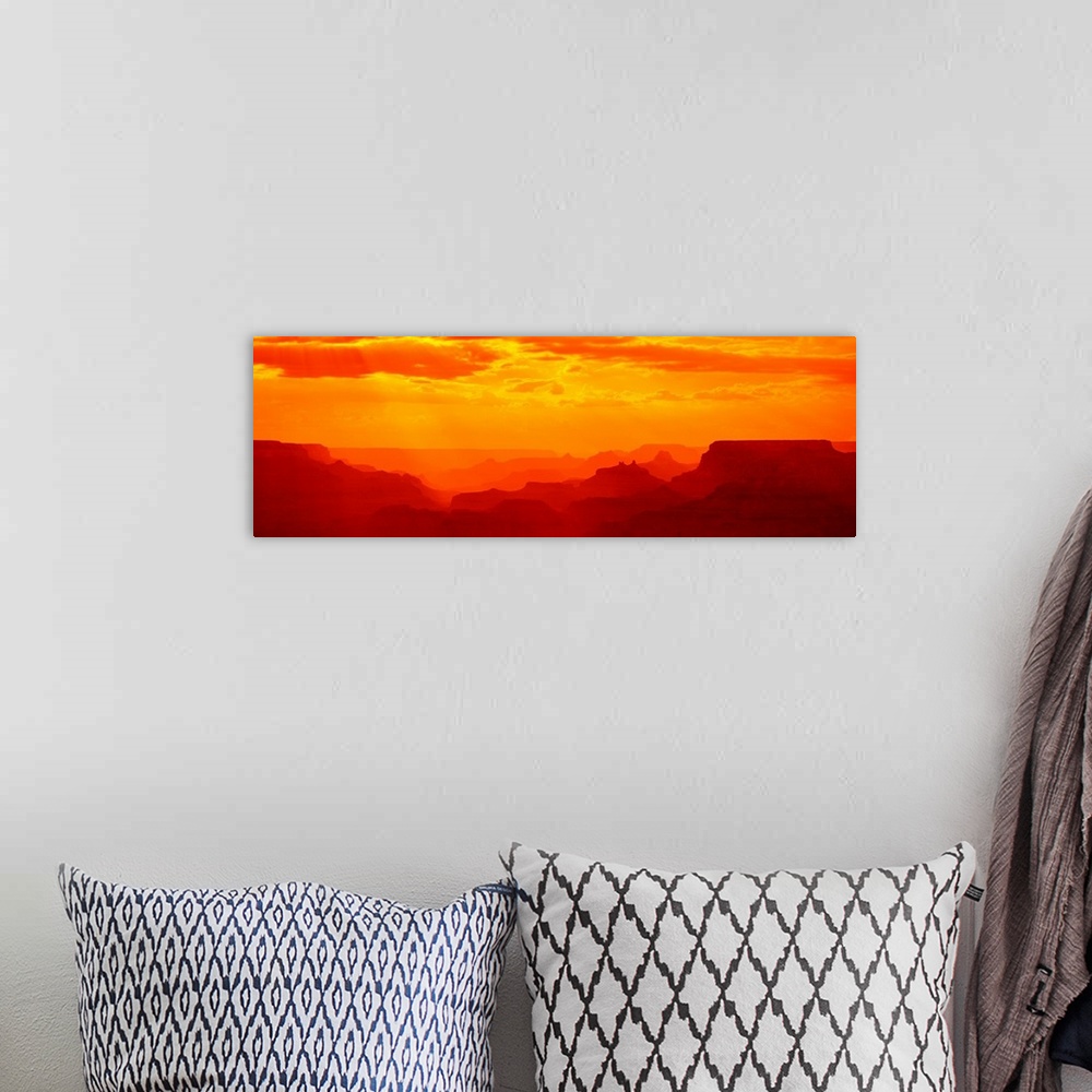 A bohemian room featuring Tonal panoramic photograph of canyon silhouettes at sunrise.