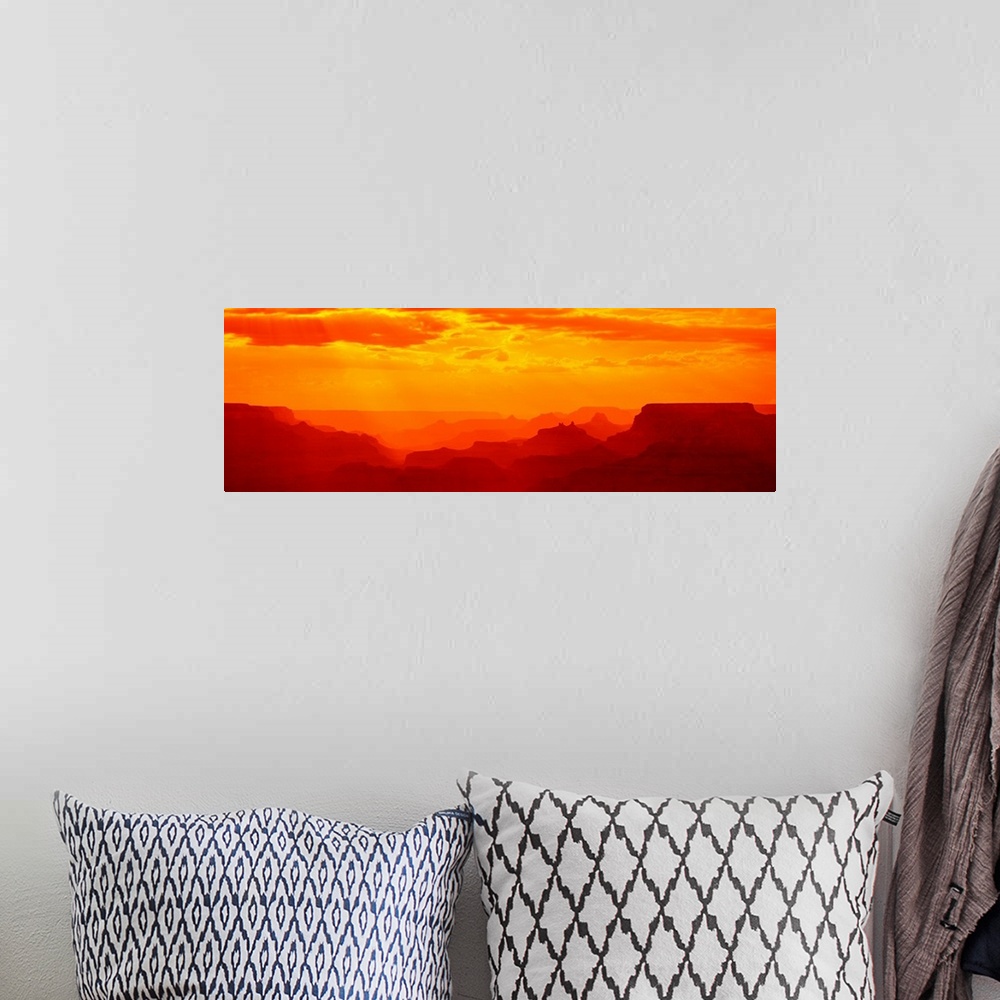 A bohemian room featuring Tonal panoramic photograph of canyon silhouettes at sunrise.