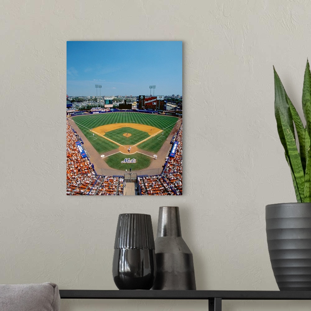 A modern room featuring Vertical, aerial photograph of Shea Stadium, full of fans during a New York Mets baseball game.