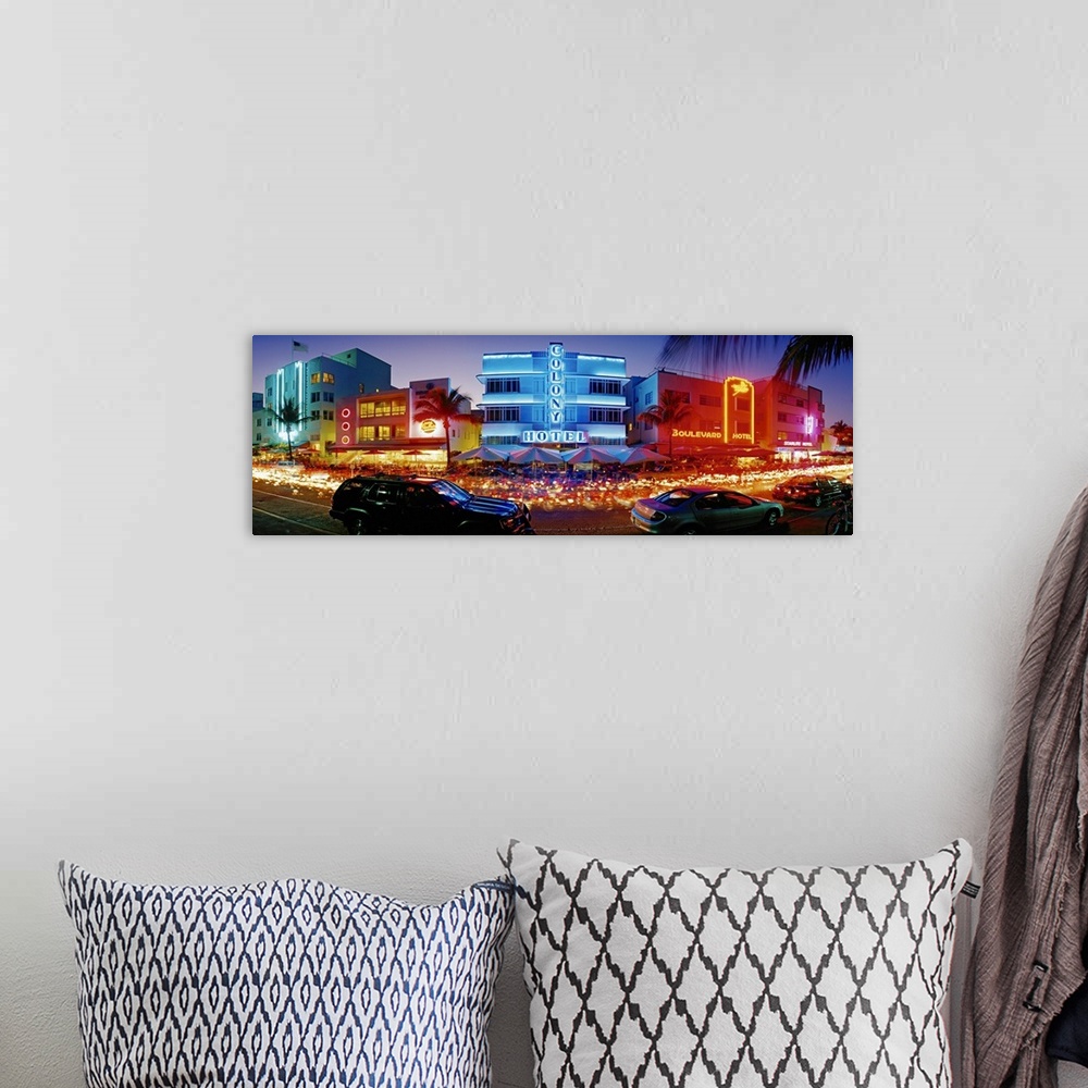 A bohemian room featuring Wide angle, giant photograph of a strip of brightly lit hotels and dance clubs at night, in Miami...