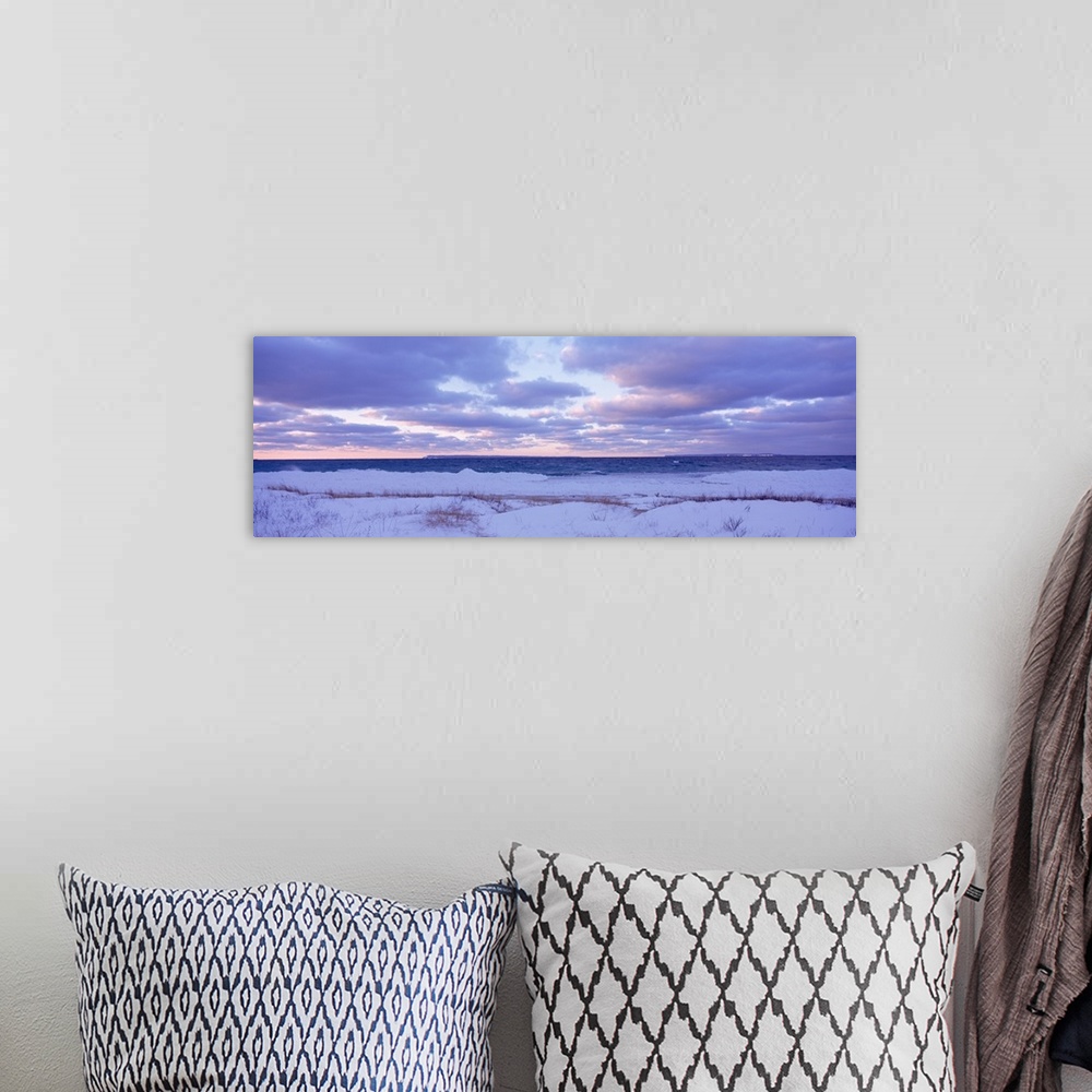 A bohemian room featuring Large, wide angle photograph of a beach off of Lake Michigan, under a sky of pastels and clouds a...