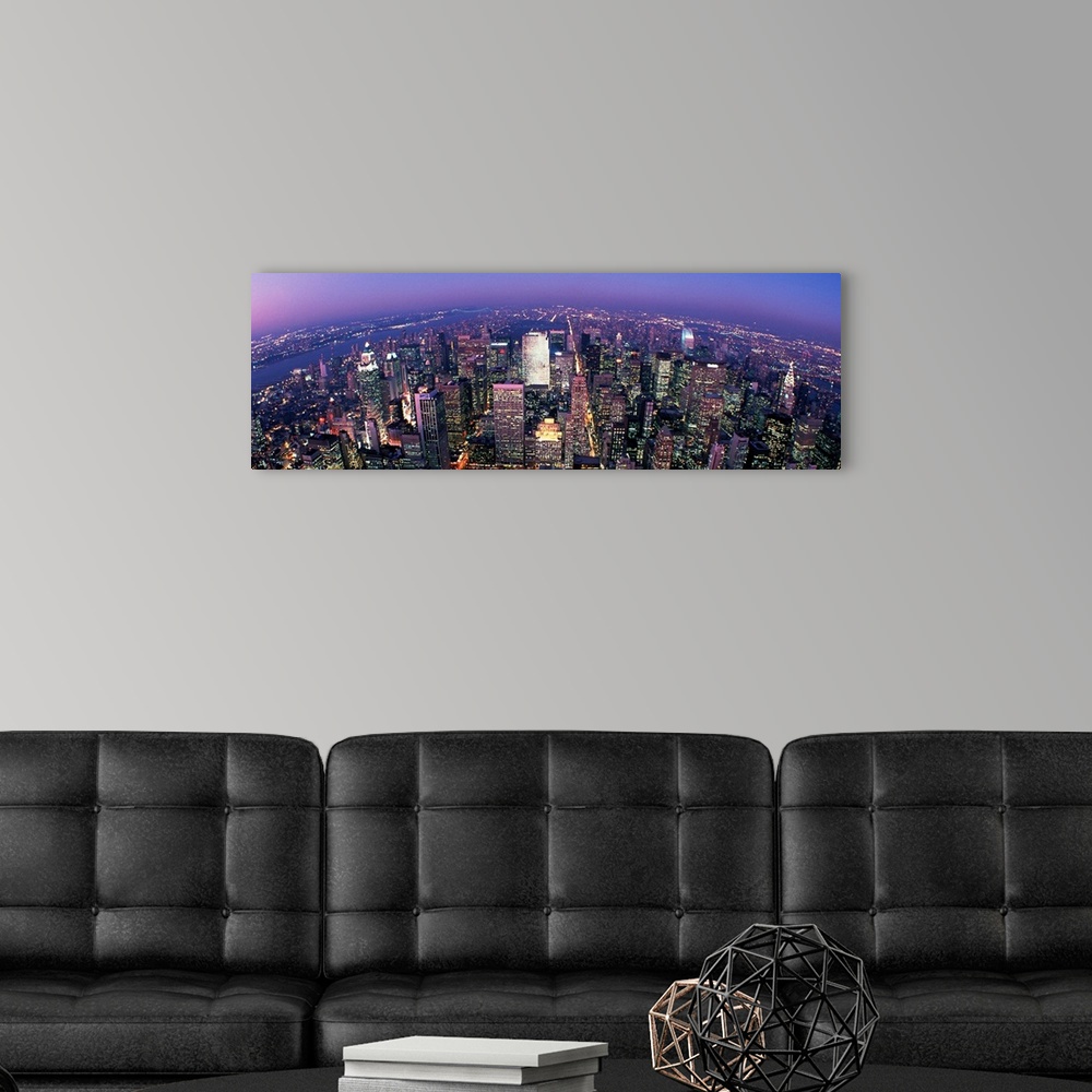 A modern room featuring Wall docor of a sky view of New York City's illuminated streets and buildings that reach towards ...
