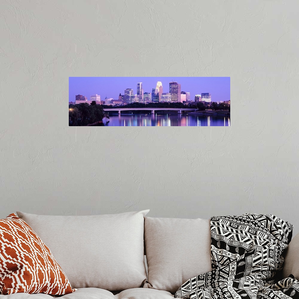 A bohemian room featuring Panoramic photograph of cityscape with downtown building lit up.  The lights and building are ref...