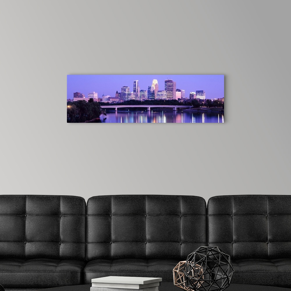 A modern room featuring Panoramic photograph of cityscape with downtown building lit up.  The lights and building are ref...