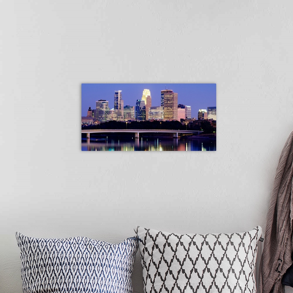 A bohemian room featuring A landscape photograph of downtown city lights reflecting water.