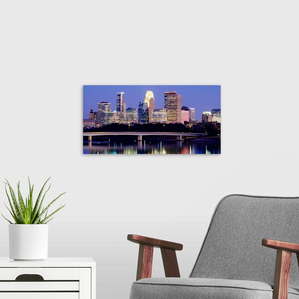 A modern room featuring A landscape photograph of downtown city lights reflecting water.