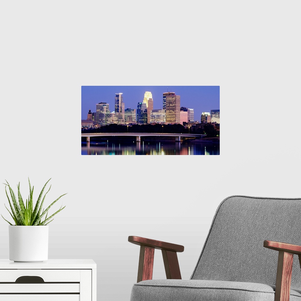 A modern room featuring A landscape photograph of downtown city lights reflecting water.