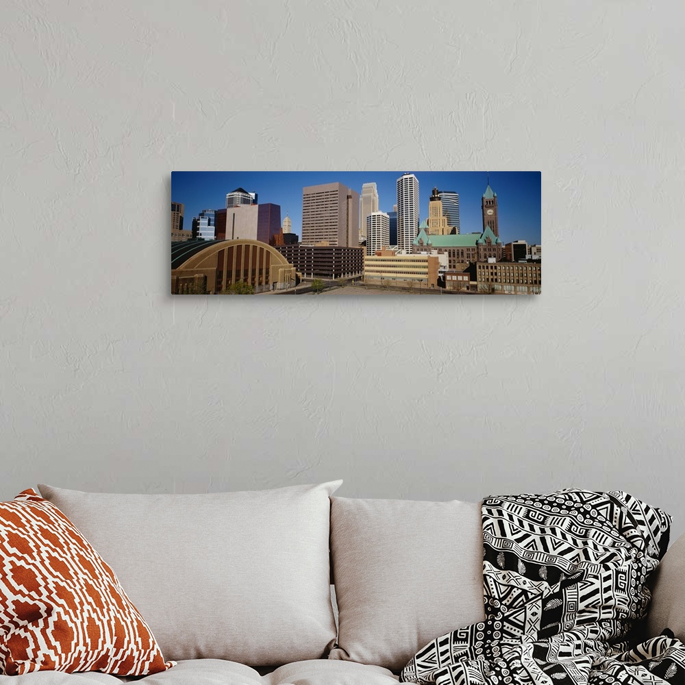 A bohemian room featuring Big, panoramic photograph of the Minneapolis skyline against a blue, afternoon sky.