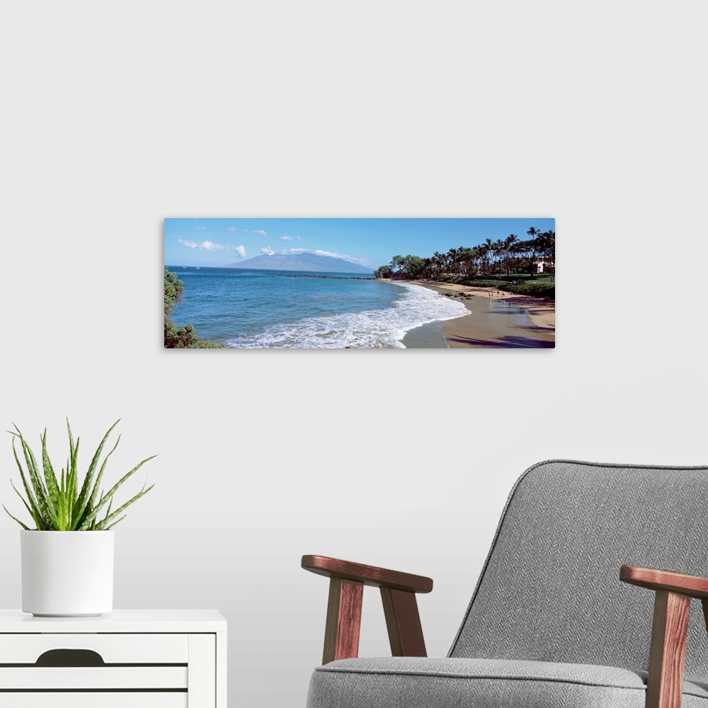 A modern room featuring This is a panoramic of a Hawaiian beach lined with palm trees and a mountain in the distance.