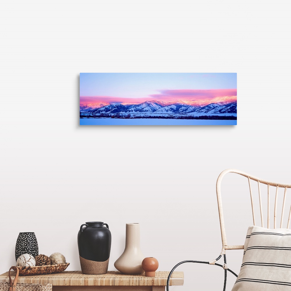 A farmhouse room featuring A panoramic snowscape photograph of plains and clouds passing over mountains at the end of the day.