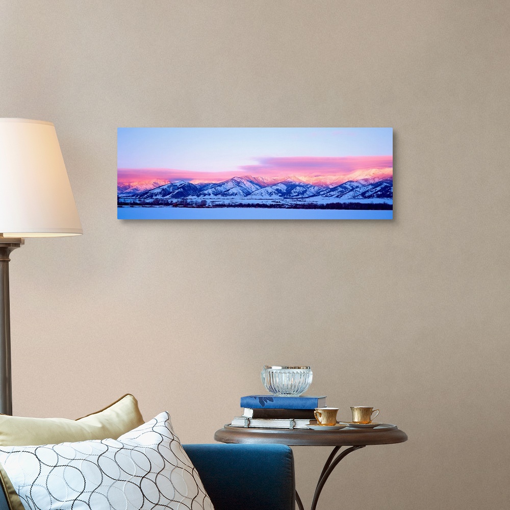 A traditional room featuring A panoramic snowscape photograph of plains and clouds passing over mountains at the end of the day.