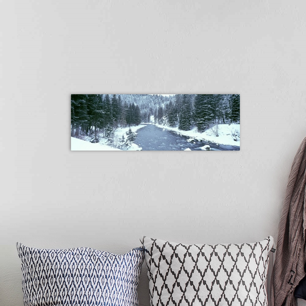 A bohemian room featuring This large panoramic shot was taken of a river during winter with the land covered in snow beside...