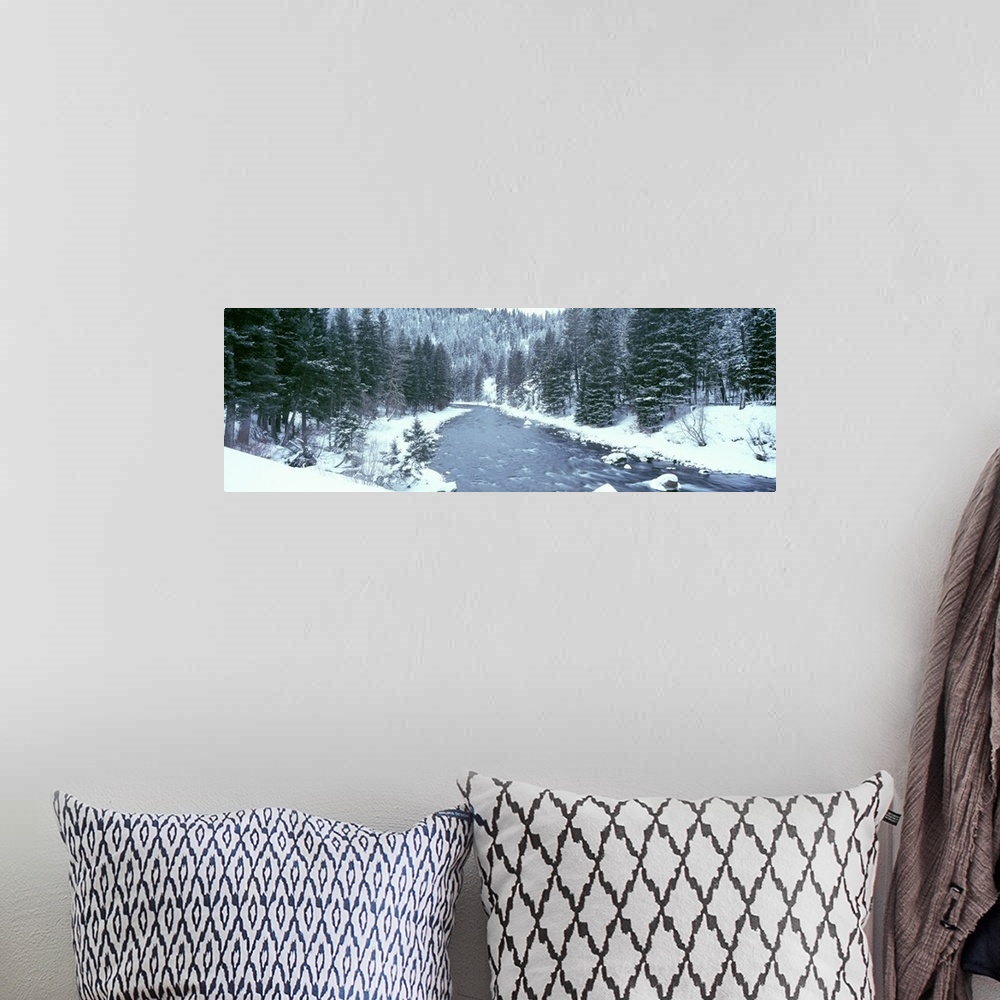 A bohemian room featuring This large panoramic shot was taken of a river during winter with the land covered in snow beside...