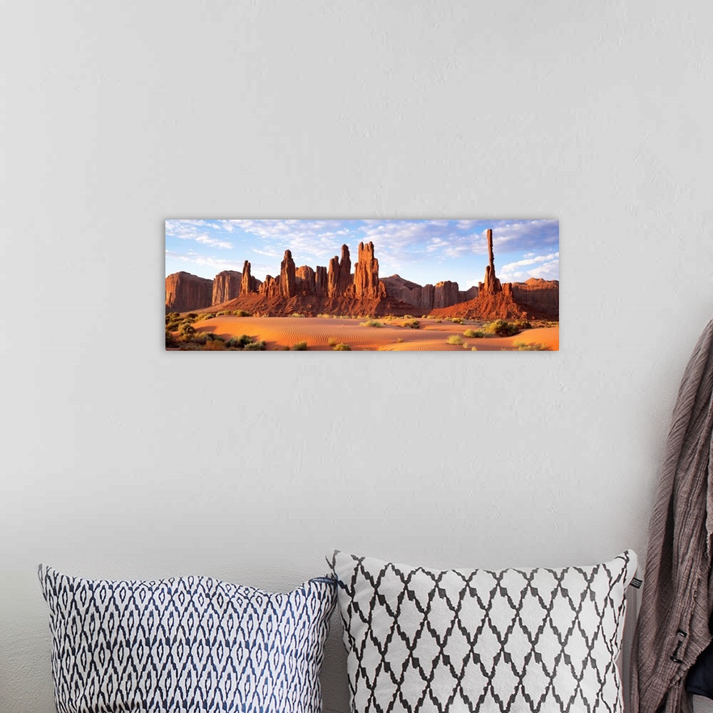 A bohemian room featuring Panoramic photograph composed of a desert landscape filled with sand and small patches of vegetat...