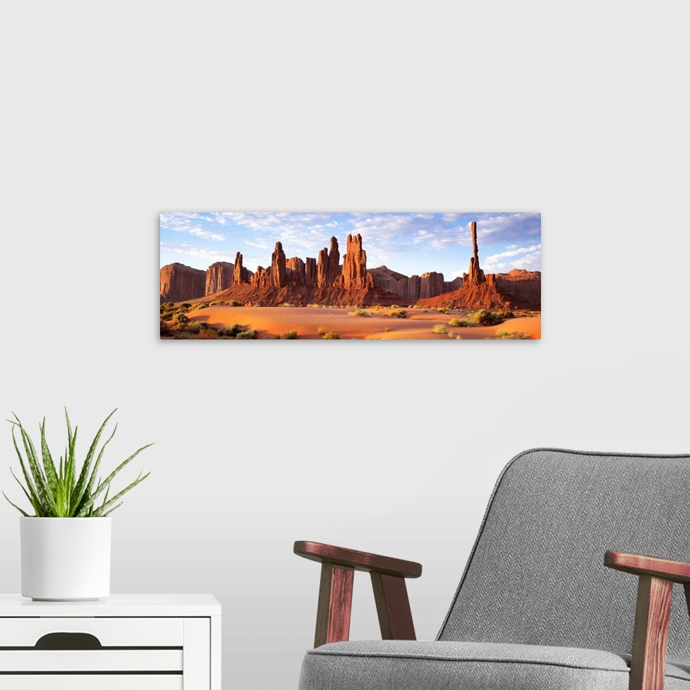 A modern room featuring Panoramic photograph composed of a desert landscape filled with sand and small patches of vegetat...