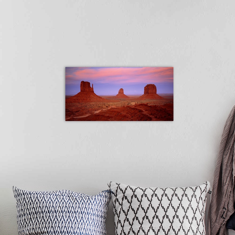 A bohemian room featuring An oversized piece that is a photograph taken of Monument Valley during sundown.