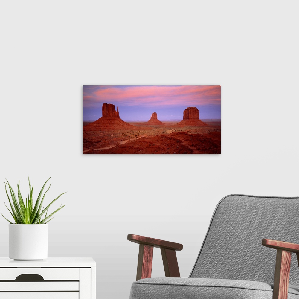 A modern room featuring An oversized piece that is a photograph taken of Monument Valley during sundown.