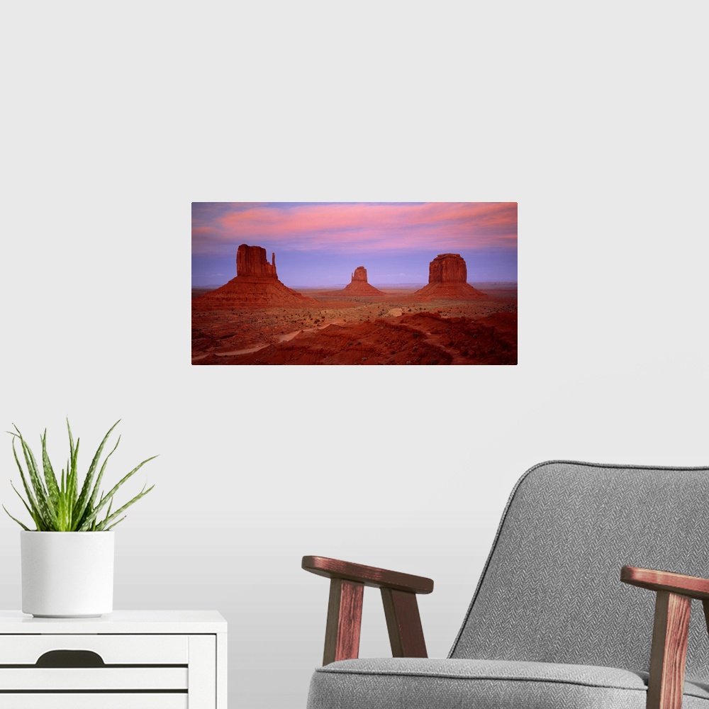 A modern room featuring An oversized piece that is a photograph taken of Monument Valley during sundown.