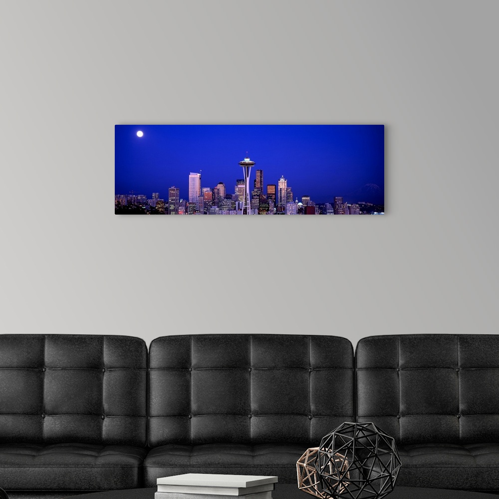 A modern room featuring The city skyline illuminated in the moonlight.