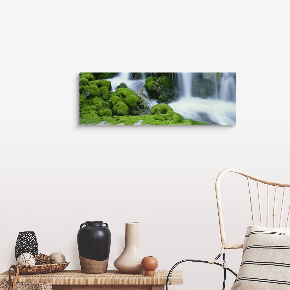 A farmhouse room featuring Oversized, horizontal photograph of a stream rushing through large, rocky terrain covered in thic...