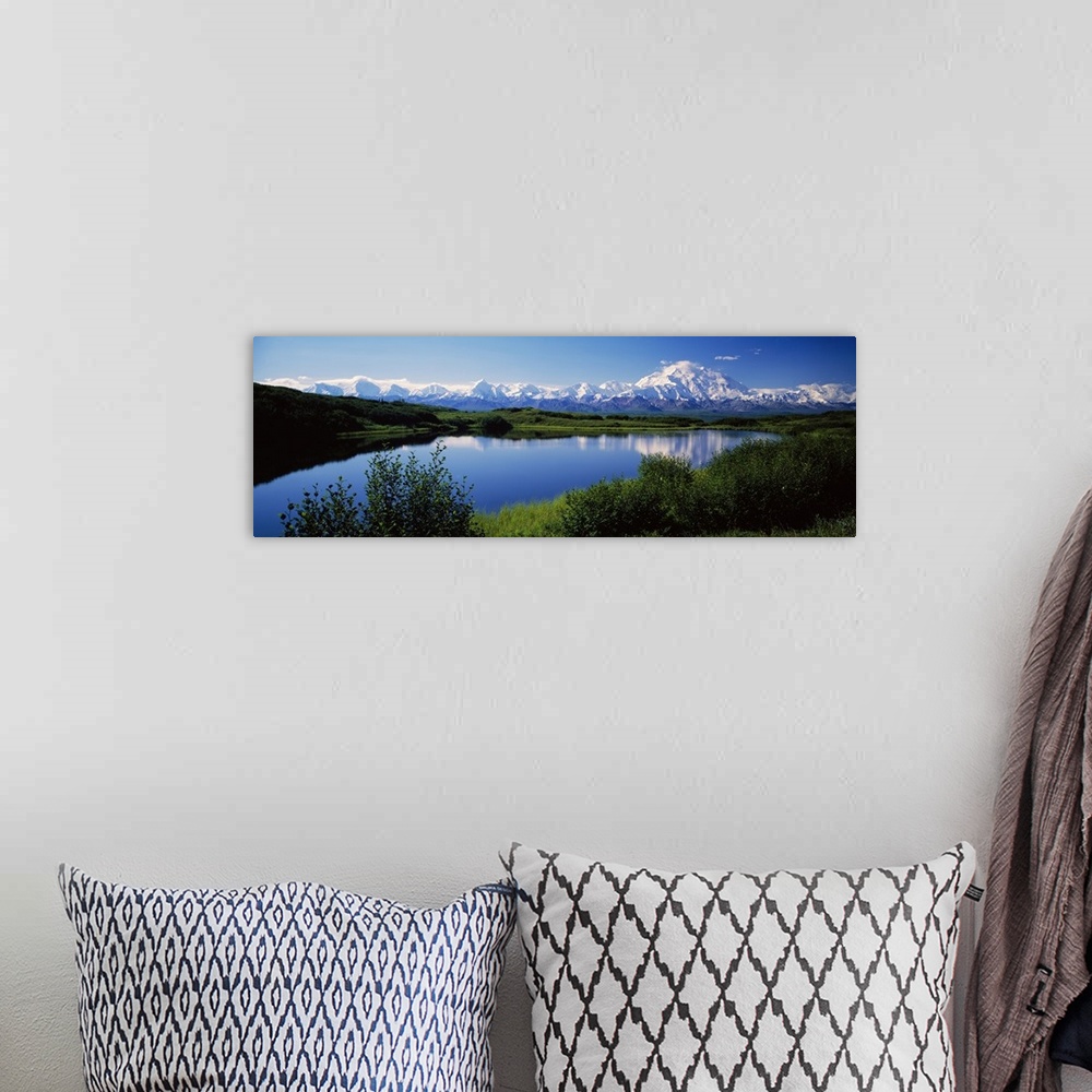 A bohemian room featuring Panoramic photograph of snow covered mountains under a clear sky with rolling grass hills and riv...
