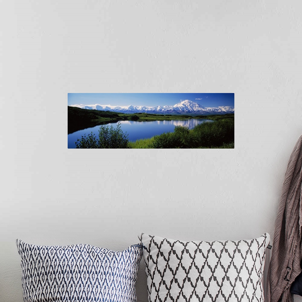 A bohemian room featuring Panoramic photograph of snow covered mountains under a clear sky with rolling grass hills and riv...