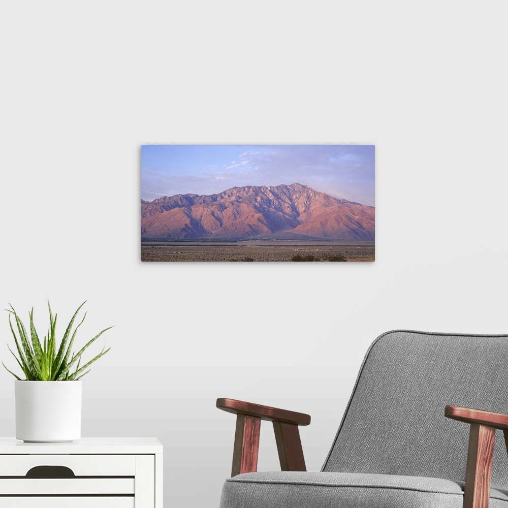 A modern room featuring Wide angle picture of San Jacinto Peak in California. The sun is setting out of view and shining ...