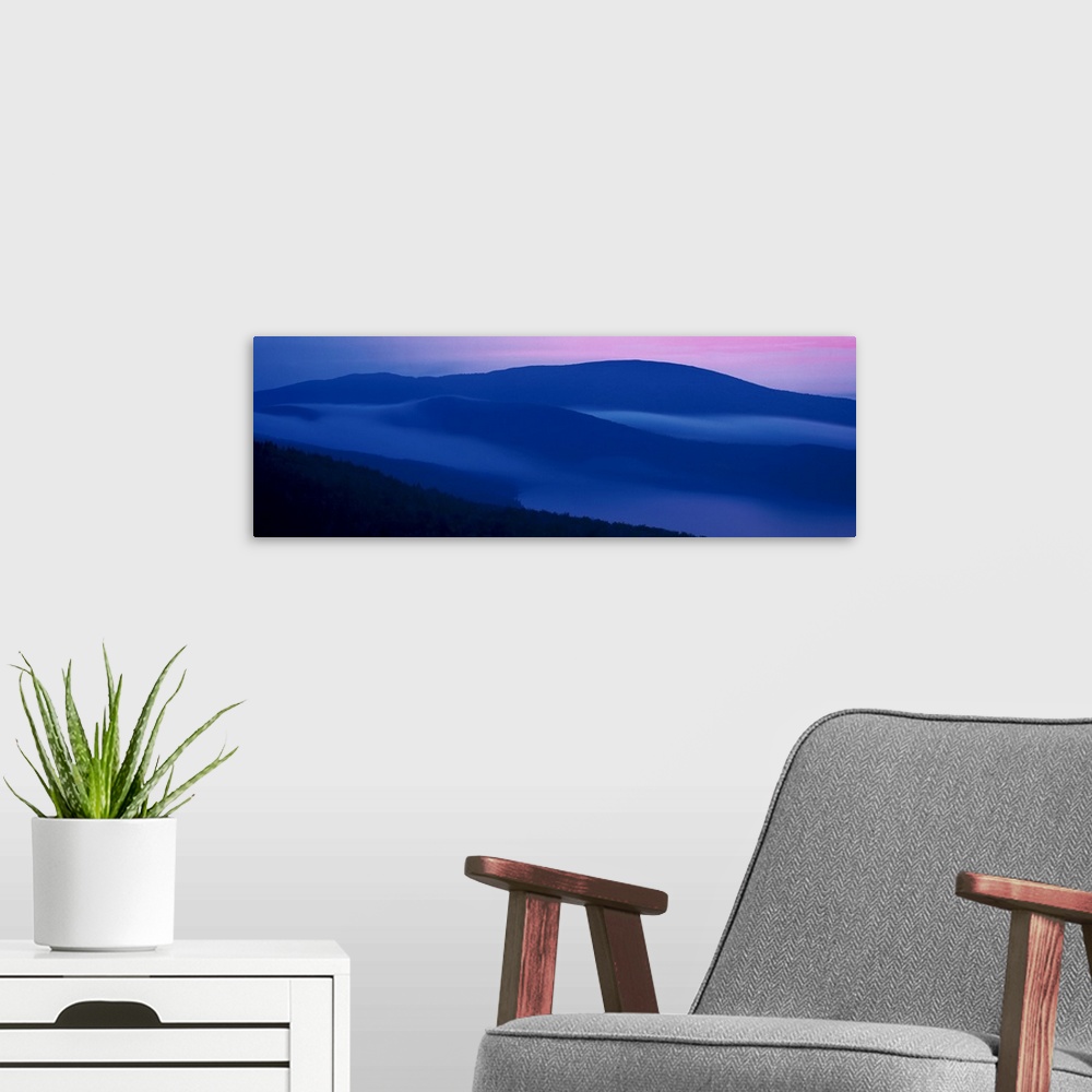 A modern room featuring Panoramic photograph on a big wall hanging of shadowed mountains at sunset at Acadia National Par...
