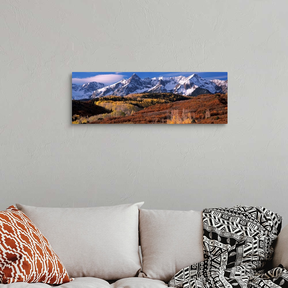 A bohemian room featuring Giant landscape photograph of a golden brown Colorado valley in front of snow covered mountains u...
