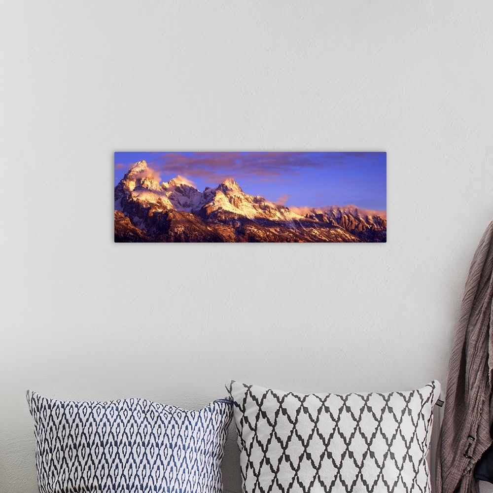 A bohemian room featuring Panoramic photograph of snow capped mountain range under a cloudy sky.