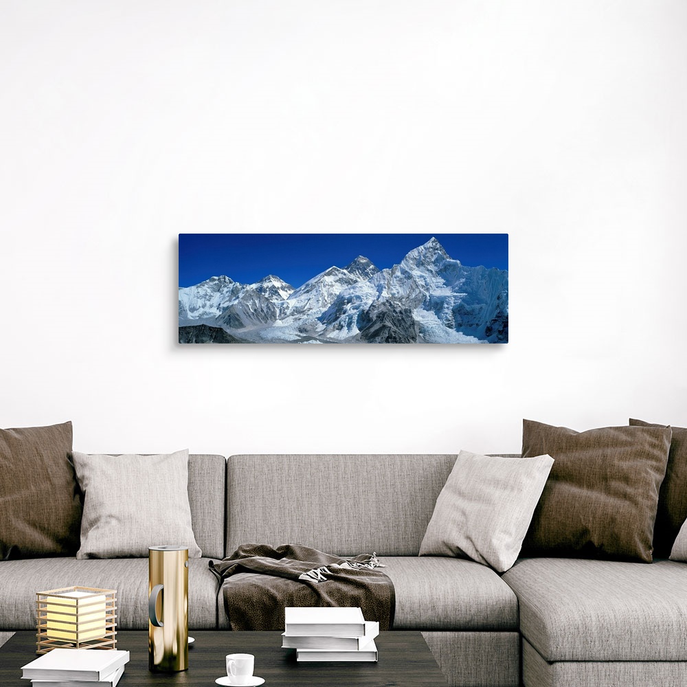 A traditional room featuring Giant, wide angle landscape photograph of snow covered Himalaya Mountains against a blue sky, inc...