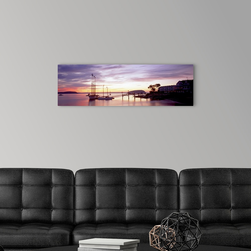 A modern room featuring Panoramic photograph sailboats at dock under a cloudy sunset with mountain silhouettes in the dis...