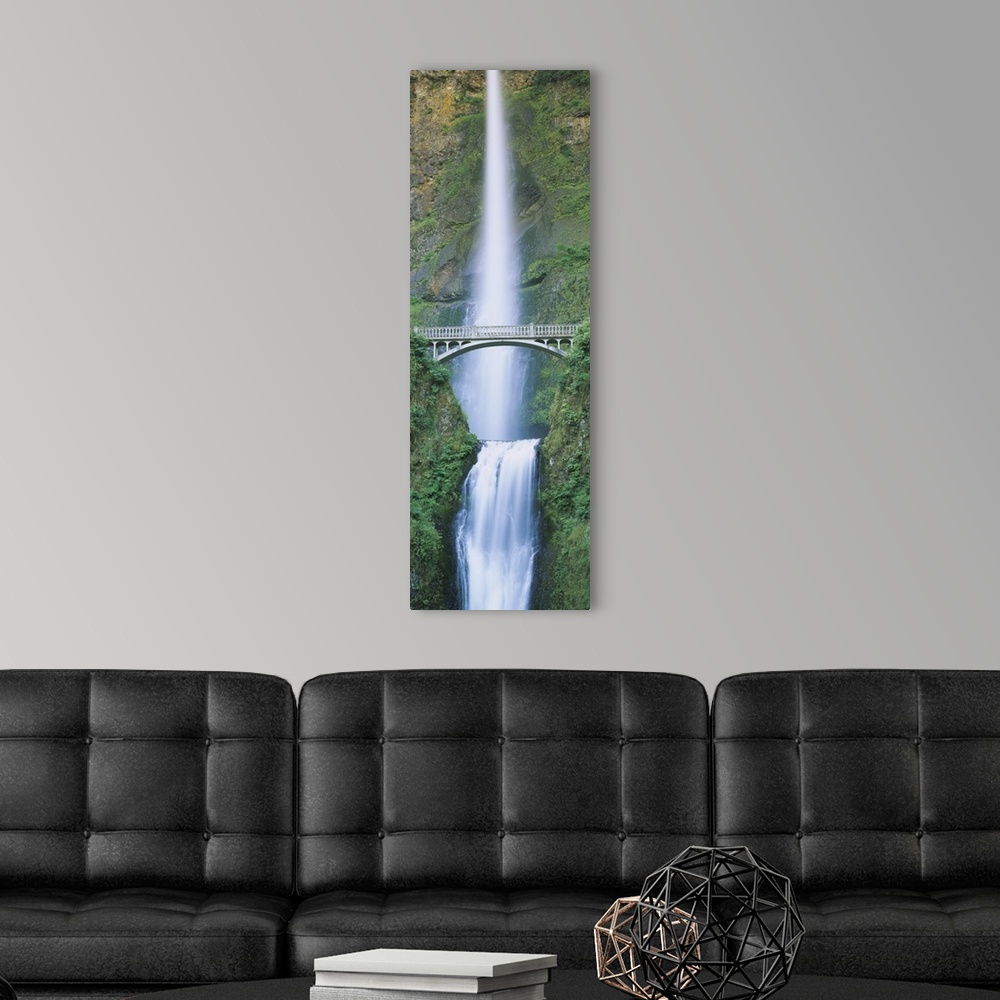 A modern room featuring Panoramic photograph displays an enormous waterfall cascading down a rocky cliff and landing into...
