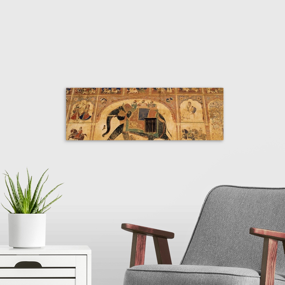 A modern room featuring This panoramic piece shows a large mural that has been painted on a wall in India. A large elepha...