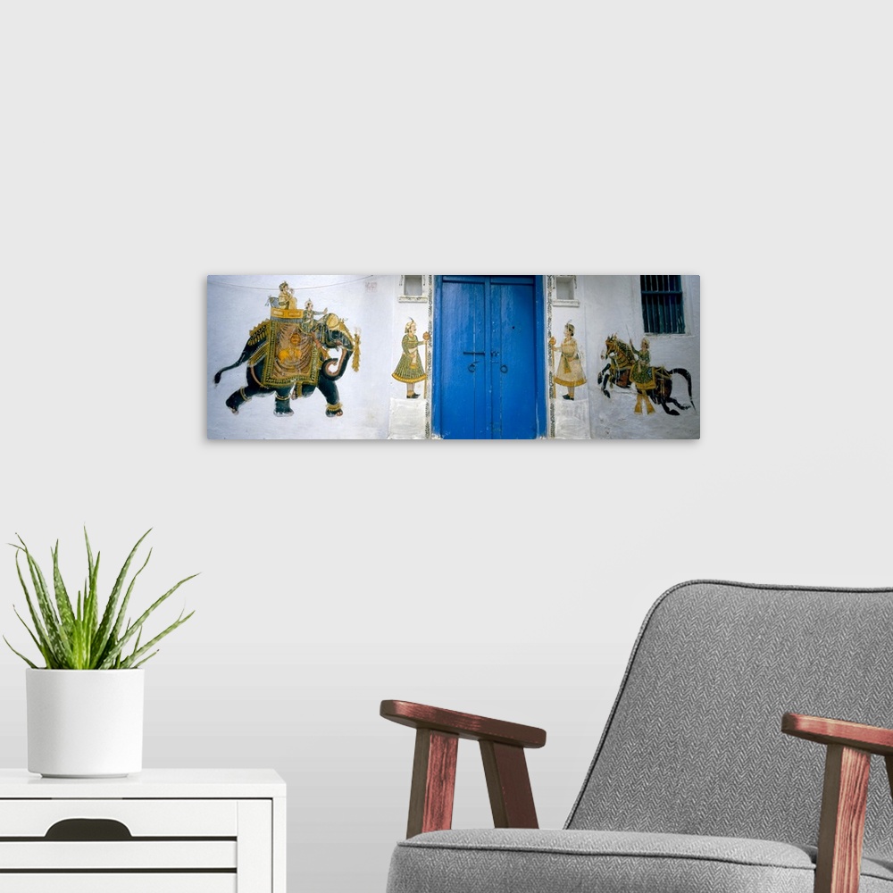 A modern room featuring Panoramic photograph taken of a mural painted on either side of bright blue doors. The mural cons...