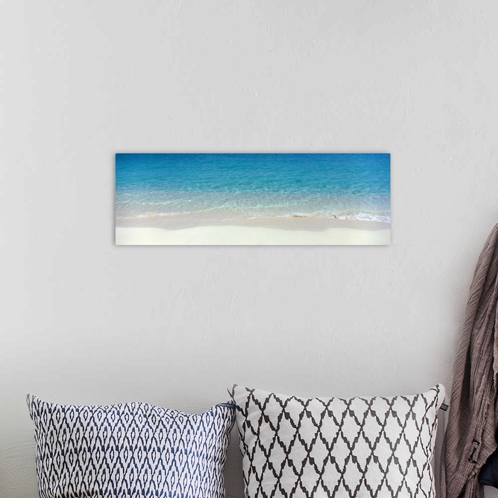 A bohemian room featuring Panoramic photograph of shoreline with wet sand and crystal clear water.