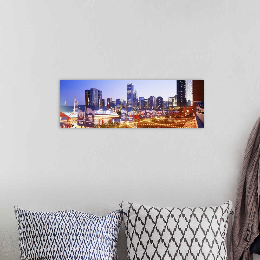 A bohemian room featuring Panoramic photograph of dock at night with city skyline in the background.  The dock is strung wi...
