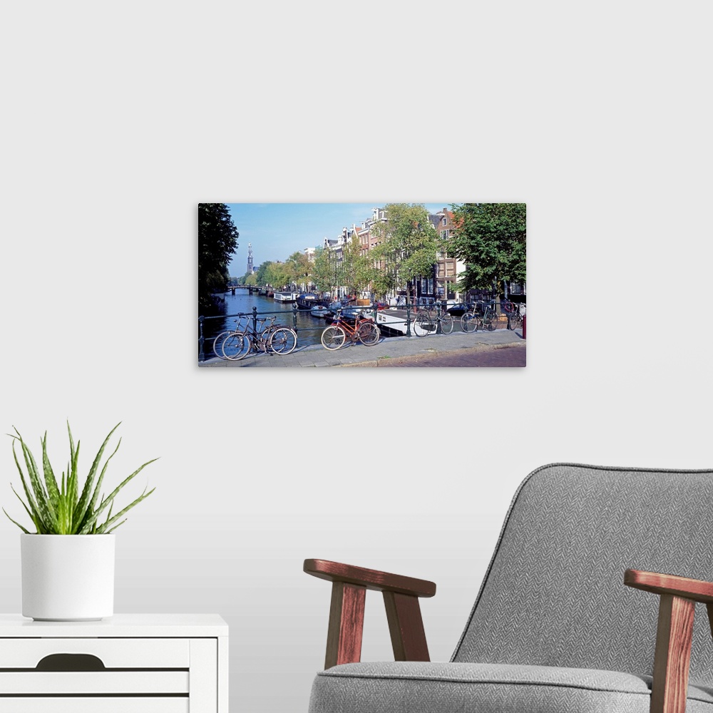 A modern room featuring Panoramic, large photograph of bicycles lined up along a bridge overlooking the water, a row of b...