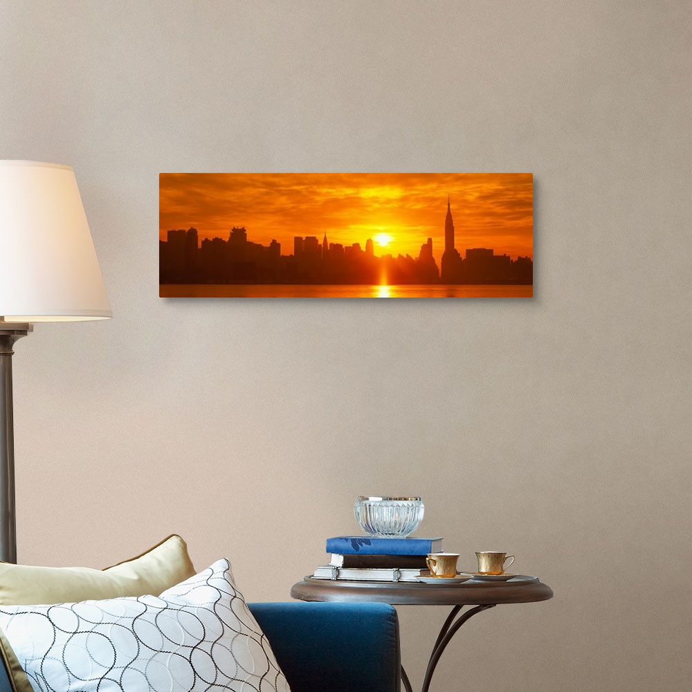 A traditional room featuring This panoramic photograph shows the sun rising over Manhattan and making silhouettes of the city ...