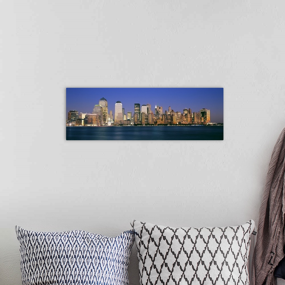 A bohemian room featuring Panoramic photograph taken of smaller skyscrapers that sit on the edge of water in New York City.