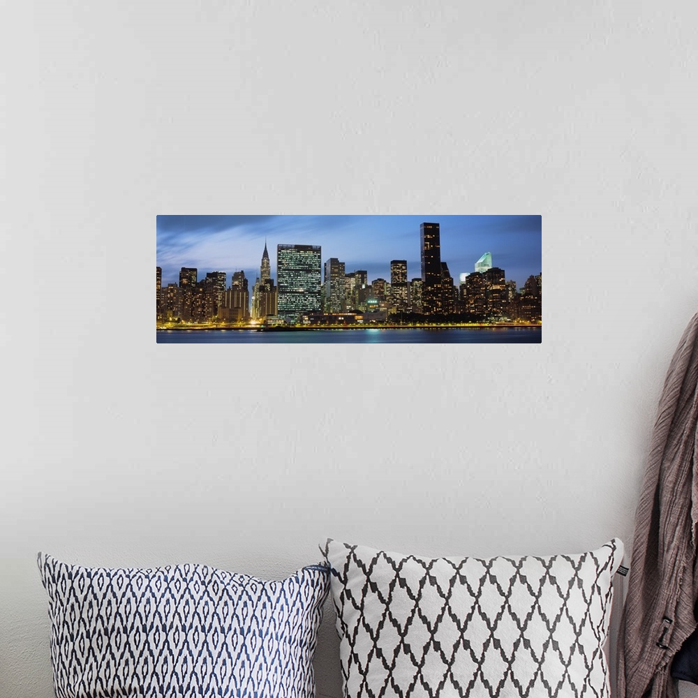 A bohemian room featuring Giant, panoramic photograph of the New York City skyline lit up at night.